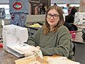  Student poses with a sewing machine